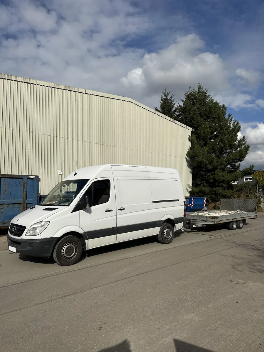 Transporter mit Anhänger beim Abtransport von Bauschutt