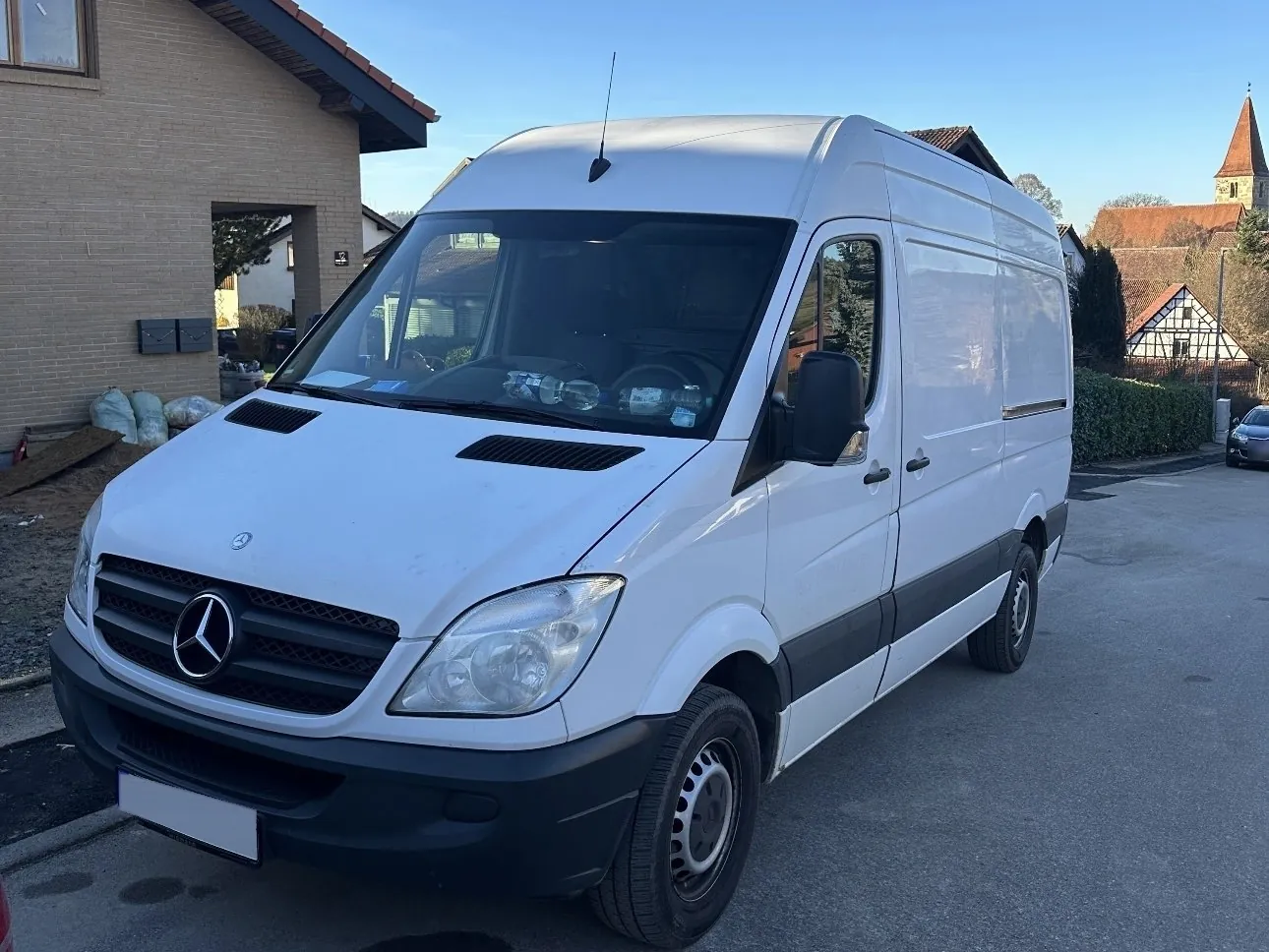 Weißer Transporter von Haushaltsauflösungen Hohenlohe vor einem Wohnhaus
